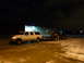 1993 Ford C-150 (Centurion Conversions) - A white Ford F-Series SUV tows a car on a trailer in a snowy lot at night.
