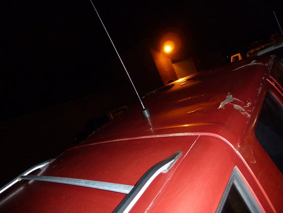 Red vehicle roof with peeling paint and antenna. No year visible