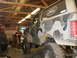 1995 Ford Bronco - Camouflaged 1995 Ford Bronco sits in a workshop, showing off its lifted suspension and off-road tires.