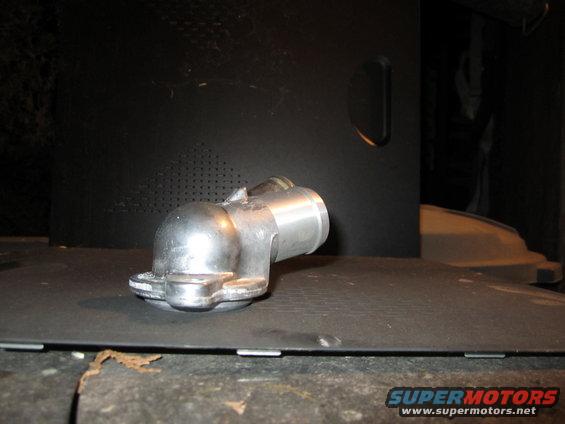 Metal water neck part on a dark surface