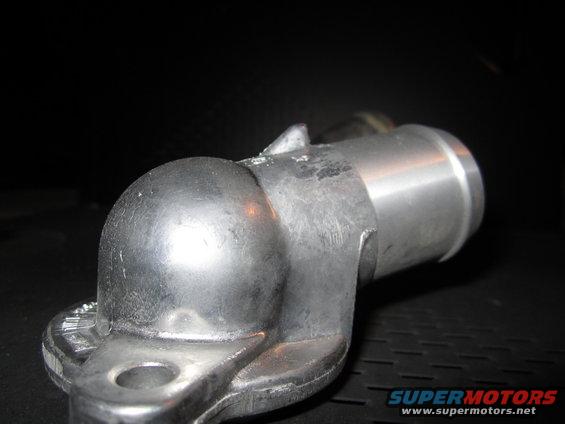 Close-up of a metal water neck part with a flange and hose connection