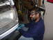 1988 Ford Bronco - A man wearing a headlamp works on the front end of a white vehicle in a garage setting.