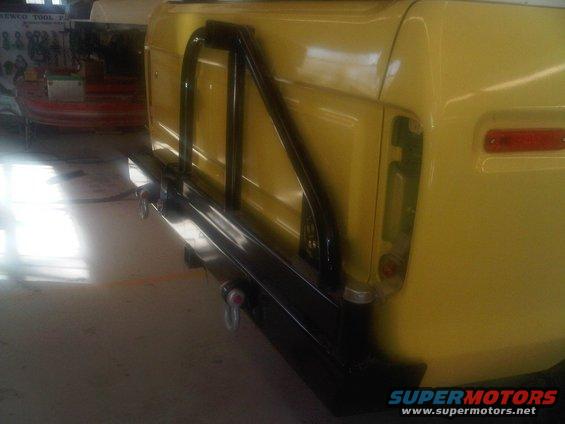 1978 Ford Bronco rear quarter panel, custom black bumper, and roll cage. Yellow paint