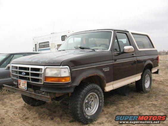 Brown 1992 Ford Bronco with tan lower trim and a white roof, viewed from the front-right