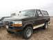 1992 Ford Bronco - A 1992 Ford Bronco is parked on sandy ground next to an RV.