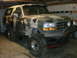 1995 Ford Bronco - This modified Ford Bronco is parked inside a garage, showing off its custom paint and off-road tires.