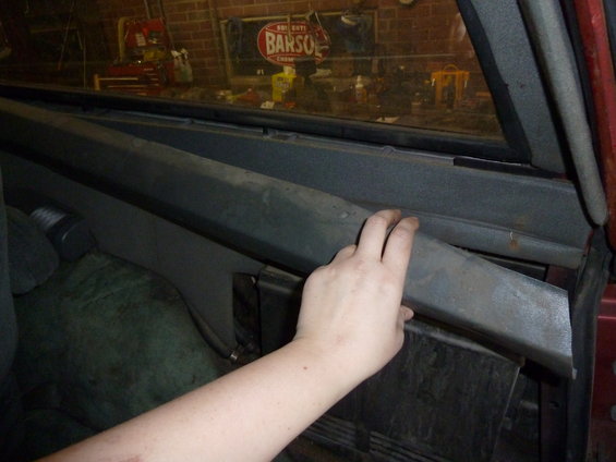 Hand touching interior trim panel inside a vehicle