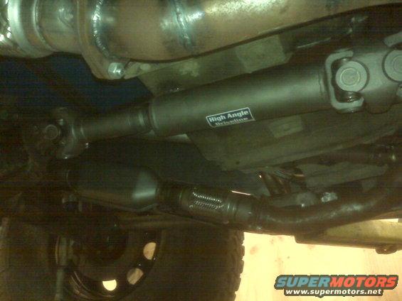 Driveshaft with 'High Angle Driveline' sticker and exhaust components visible underneath a vehicle