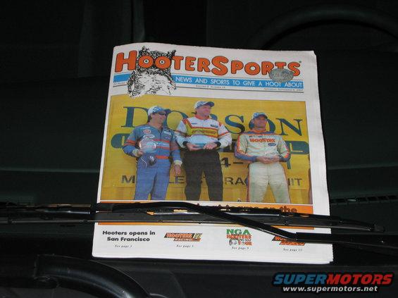 Newspaper race car drivers and Hooters logo