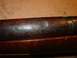 2003 Ford Crown Victoria - Detail of a wooden firearm stock showing wear and a metal band.