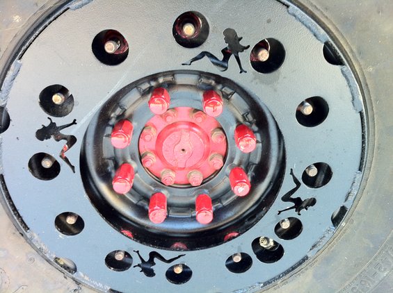 Spare tire with black cutouts of pin-up girls around the rim