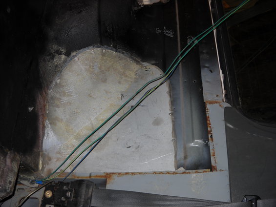 Interior view of metal paneling, wiring, and seatbelt