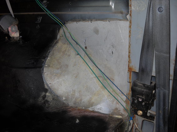 Interior view of wiring and seatbelt mechanism in a vehicle