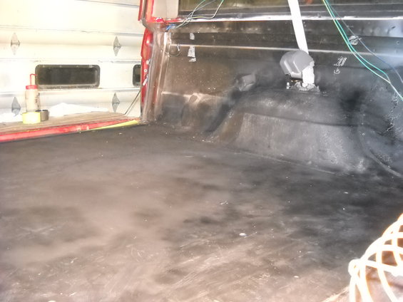Truck bed interior with black liner and red tailgate