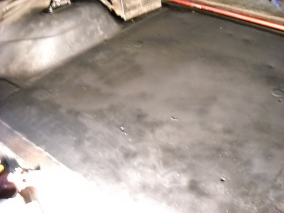 Dark, textured floor of a vehicle interior, possibly a truck bed or cargo area