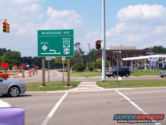 Street signs for Woodward Ave, I-75, and I-24 at an intersection with a Mobil gas station