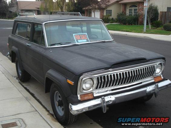 1977 Jeep Cherokee parked on a residential street with a 'FOR SALE' sign in the window