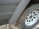 1977 Jeep Cherokee - A close-up view of the side of a vehicle, focusing on the fender and a tire on a white rim.