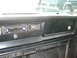 1977 Jeep Cherokee - The interior dashboard of a 1977 Jeep Cherokee features an aftermarket Pioneer stereo and a clock, with another Jeep visible through the wi…