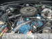 1977 Jeep Cherokee - Close-up view of an engine bay, showing the engine block, air cleaner, and battery with visible text.