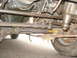 1977 Jeep Cherokee - Underside view of a vehicle's steering components, including tie rods and a shock absorber, with a tire visible.