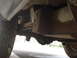 1977 Jeep Cherokee - A low-angle shot reveals the undercarriage components, including leaf springs and a differential, with a visible watermark.