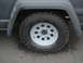 1977 Jeep Cherokee - Close-up of a 1977 Jeep Cherokee's front wheel and fender, showing a gray primer finish.