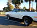 1973 Ford Ranchero - A white 1973 Ford Ranchero is parked in a lot, with palm trees visible behind it.