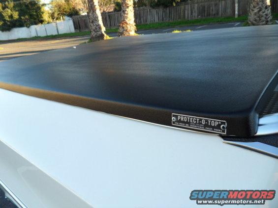 White vehicle with black Protect-O-Top bed cover, close-up side view