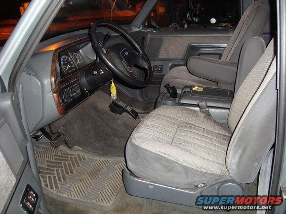1991 Ford Bronco interior, gray fabric seats, wood trim dashboard, floor mats, and a car phone