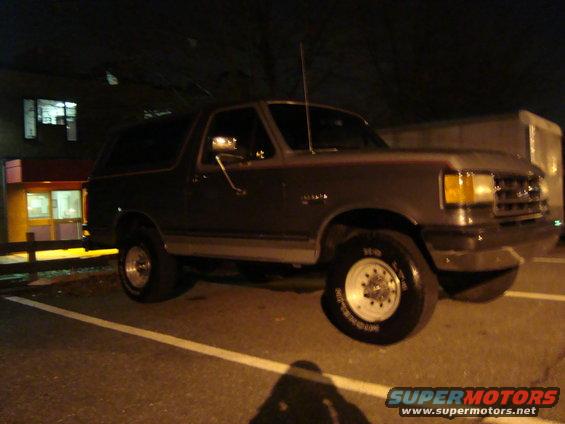 Dark gray 1991 Ford Bronco parked at night, side view