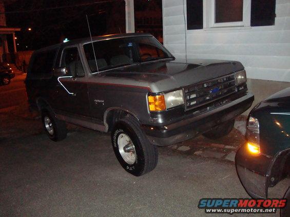 1991 Ford Bronco parked at night next to another vehicle