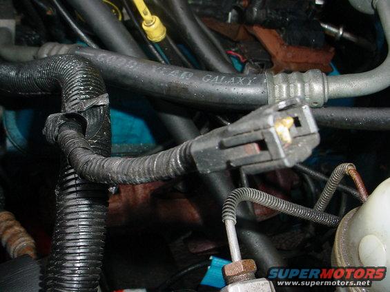 Engine bay with hoses and electrical connectors. A hose reads 'GOODYEAR GALAXY'