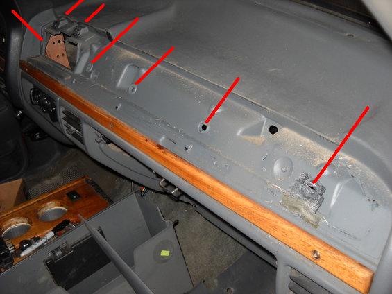 Dashboard interior with red lines pointing to various mounting points and holes