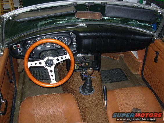 1971 MG B interior with wood steering wheel, brown seats, and dashboard gauges