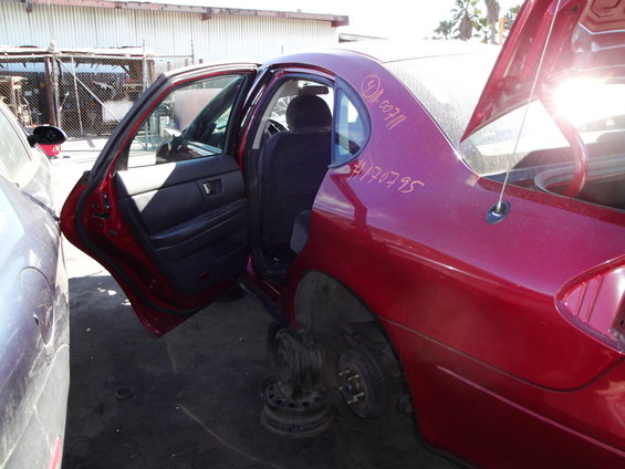 Red 2003 Ford Taurus rear door panel with open doors and missing wheels