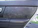 2003 Ford Taurus - The interior door panel shows significant wear and discoloration on the textured insert.