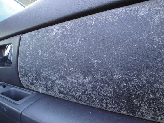 Dark gray interior door panel with white discoloration and scratches. Chrome door handle visible