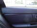 2003 Ford Taurus - Close-up of a dark interior door panel, a perforated insert and a chrome door handle.