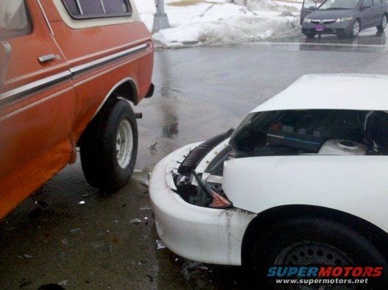 Orange 1979 Ford Bronco side view, white car front end damaged