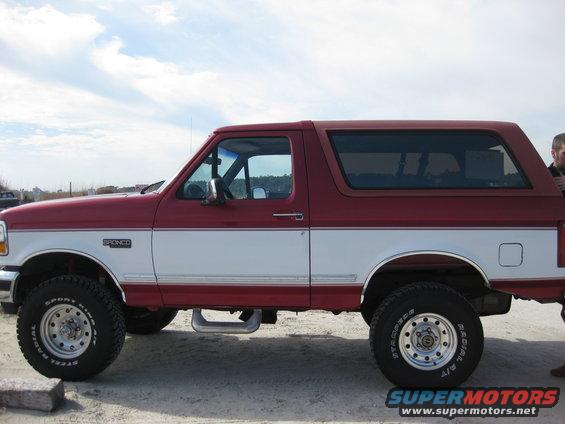 1995 Ford Bronco, two-tone red and white, side view. "BRONCO" badge visible on fender