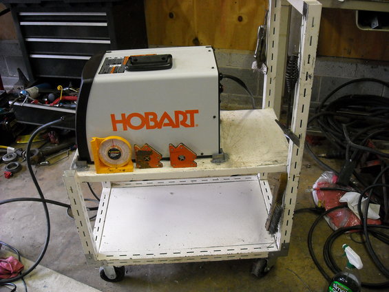 Hobart welder on a rolling cart with a scale and magnetic clamps