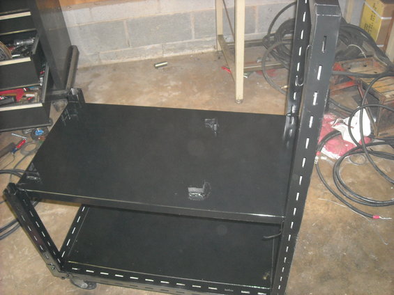 Black rolling tool cart with two shelves and metal uprights with holes