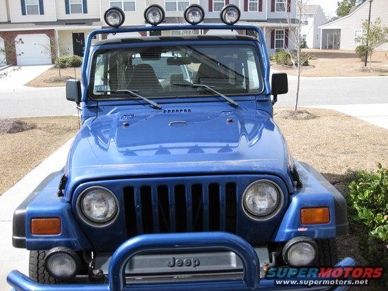 Blue Jeep Wrangler with light bar on roof, front view