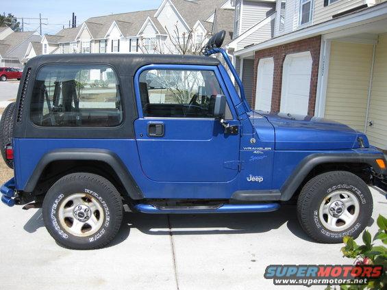 Blue Jeep Wrangler with a black hardtop, seen from the side. The vehicle has a snorkel and side steps