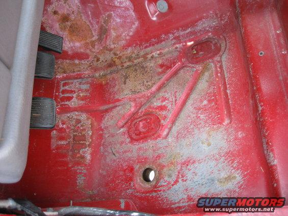 driver's side floor pan with pedals and rust spots