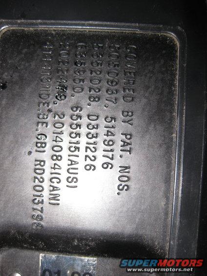 Close-up of a metal plate with embossed text and numbers, including patent information and dates