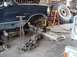 1992 Ford Bronco - The vehicle is undergoing mechanical work in a cluttered garage setting with a large tire visible in the background.