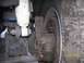 1970 Ford Bronco - Close-up view of the front suspension and tire of a vehicle, showing rust and wear.