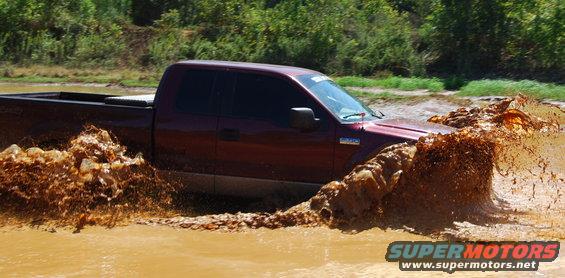Maroon 2005 Ford F-150 splashing through mud